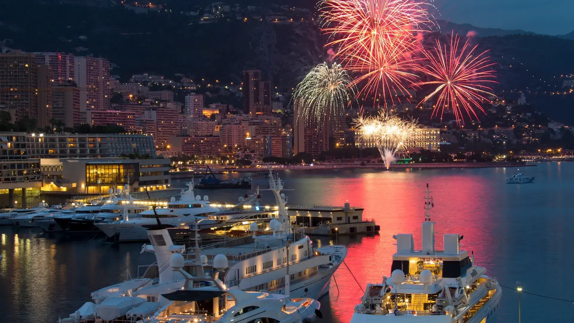 Superyachten im Hafen von Monaco bei Nacht mit Feuerwerk