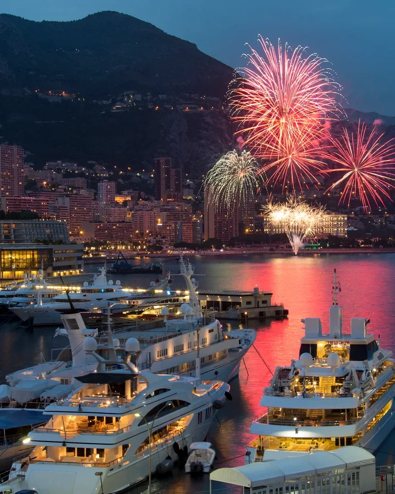 Yachten im Hafen von Monaco bei Nacht mit Feuerwerk